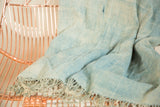 Hand woven denim indigo textile with soft folds and naturally dyed color variations.