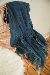 Hand woven indigo textile throw, showcasing deep blue texture and artisanal fringe.