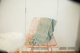 Hand-woven vintage African indigo textile throw, featuring faded denim blue and fringed edge.