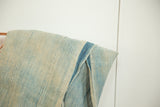 Folded vintage Mossi Indigo textile showing hand-woven texture and a deep blue stripe.