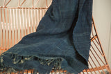 Indigo African textile with subtle hand-woven grid pattern and fringed edge.