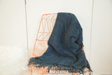 Collectible Denim Mossi Indigo African textile throw draped, showcasing hand-woven texture and fringe.