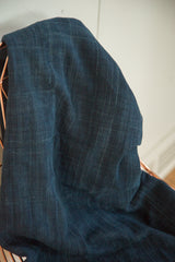 Deep indigo hand-woven cotton textile, showcasing subtle textured stripes and stitched details.