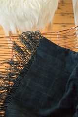 Fringed edge and supple handwoven texture of a vintage indigo African textile.