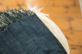 Textured hand-woven deep indigo African textile with subtle dye variations and fringe.
