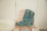 Hand woven indigo African textile throw with varied texture and soft fringed edge.