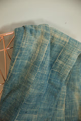 Hand-woven cotton indigo textile detail, showing variegated denim blue tones and texture.