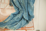 Vintage hand woven indigo textile draped, showcasing intricate white batik patterns.