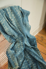 Vintage African indigo textile throw showcasing hand-dyed batik patterns and textured folds.