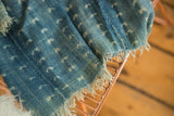 Vintage indigo African textile showing hand-woven texture, subtle patterns, and visible seam.
