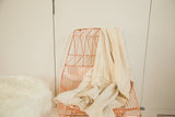 Natural African hand-woven cotton throw, displaying its subtle texture and supple drape.