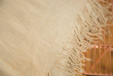 Natural beige hand-woven African cotton textile, showcasing detailed weave and long fringe.