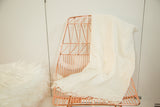 Natural hand woven African textile throw with soft texture, fringe, and subtle vintage marks.
