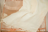 Hand-woven natural African textile throw with fringed edge and subtle vintage character.