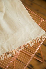 Hand-woven natural African cotton textile throw, delicate texture and fringed edge.