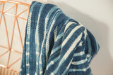 Vintage African indigo textile with handwoven blue and cream striped patterns and soft texture.