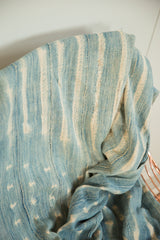 Intricate hand-woven blue and cream patterns on a vintage African indigo textile.