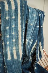 Hand-woven indigo African textile with intricate white resist-dyed patterns and soft texture.