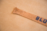 Light tan felt banner segment with worn texture and partial blue 