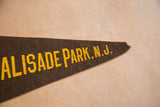 Brown felt Palisade Park N.J. pennant tip with yellow lettering and aged edge.