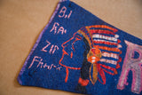 Worn blue felt pennant with faded pink lettering and painted Indian headress.