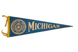 Vintage 1960s blue felt University of Michigan flag with gold crest and text.