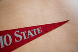 Vintage red felt Ohio State pennant's pointed tip with silver STATE letters.