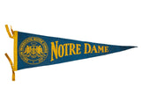Vintage blue felt Notre Dame University pennant with yellow crest and text, 8.5x25.