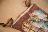 Vintage brown felt Boston pennant close-up, showing hanging ties and Bunker Hill Monument print.