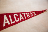Vintage red felt 'ALCATRAZ' pennant, white letters showing texture and folds.