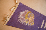 Vintage Hackettstown felt pennant detail: beige ties, purple felt, and Native American man's headdress.