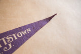 Worn, pointed tip of the purple felt Hackettstown pennant with white lettering.