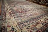 Antique Kermanshah carpet corner, rich cochineal red and navy scrolling floral motifs.