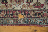 Antique Kermanshah carpet border detail, showing a large hole exposing the wood floor.