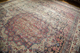 Antique Kermanshah rug's scalloped medallion, cochineal red, blue, and camel floral designs.