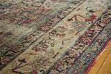 Antique Kermanshah carpet's even wear revealing foundation, scrolling floral motifs in red, blue, camel.