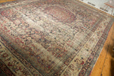 Kermanshah carpet corner detail, scrolling floral field, cochineal red and navy, with wear.