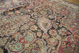 Worn scrolling floral design on antique Persian Kermanshah carpet, cochineal red, navy, camel.