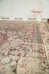 Antique Persian Kermanshah carpet detail: cochineal red, camel, navy blue scrolling floral pattern, mostly even wear.