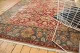 Distressed vintage Agra carpet detail, faded red field, and teal border with intricate vinery.
