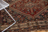 Antique Kamseh rug featuring madder red field geometric patterns and ivory border with bird motifs.