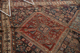 Antique Kamseh carpet, traditional madder red field with serrated contours and stylized motifs in navy and ivory.
