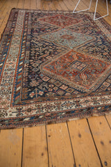 Antique Kamseh rug corner with secured fringe, geometric serrated border, madder red, and navy.