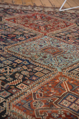 Antique Kamseh rug's detailed tribal patterns in madder red, navy blue, and seafoam blue with aged patina.