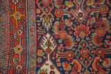 Fine detail of Herati-inspired motifs in navy, brick red, and saffron on the vintage Bibikabad rug.