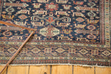 Antique Shirvan rug's classic Kufic border, geometric field, and worn ends.