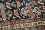Finely woven antique Shirvan rug close-up: geometric perepedil motifs and classic Kufic border.