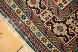 Antique Shirvan rug close-up: finely woven Kufic border, indigo, red, beige, and worn fringe.
