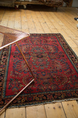 Vintage American Sarouk rug detail: central palmette, blue floral vinery, and red ground.