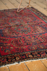 Tattered fringe and dark border on vintage American Sarouk rug with red floral vinery.